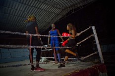 In this Jan. 24, 2017 photo, Olympic silver medalist Emilio Correa Jr., center, instructs Idamerys Moreno, right, and Legnis Cala, at a sports center in Havana, Cuba. Once when the women were kicked out a of boxing gym, Correa Jr. stepped in to help some of them find another gym while they push top Cuban officials to support female boxing. AP/Ramon Espinosa