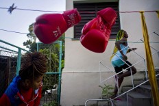 In this Jan. 19, 2017 photo, boxer Legnis Cala runs up a flight of stairs in the backyard of her house, in Havana, Cuba. "I see myself at the Olympics in Japan 2020," Moreno said. "That's my dream." Pictured at bottom left is boxer Idamerys Moreno. AP/Ramon Espinosa

