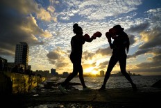 In this Jan. 30, 2017 photo, boxers Idamerys Moreno, left, and Legnis Cala, train during a photo session on Havana's sea wall, in Cuba. Moreno and Cala are part of a group of up-and-coming female boxers on the island who want government support to form Cuba's first female boxing team and help dispel a decades-old belief once summed up by a former top coach: "Cuban women are meant to show the beauty of their face, not receive punches." AP/Ramon Espinosa