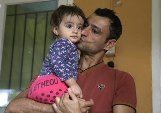 Iraqi asylum seeker Khairullah kisses his daughter Rawan during an interview with The Associated Press at a temporary home in Puncak, West Java, on Jan. 31. For thousands of asylum seekers and refugees from Iraq, Somalia and other conflict-scarred countries, Indonesia is an often years-long hiatus in their lives as they wait for the United States or another country to accept them. President Donald Trump's travel ban on seven Muslim countries and suspension of the US refugee program has now made their tenuous situation even more uncertain.