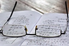 A pair of glasses belonging to a student lay on a textbook on Javanese script. Most of the palace servants are old and wear reading glasses. JP/ Aditya Sagita