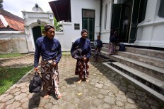 Palace servants leave the kraton's library, which is being used as a classroom. JP/ Aditya Sagita