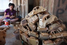 A villager crafts a wooden miniature of the Volkswagen Beetle in the village of Wates in Karanganom district, Klaten, Central Java. The products are sold to customers in countries as far as Iran and Turkey. JP/ Ganug Nugroho Adi