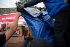 Volunteers unload aid distributed by the National Disaster Mitigation Agency (BNPB) for people affected by landslides in Songan village on Monday, February 13, 2017. JP/ Anggara Mahendra
