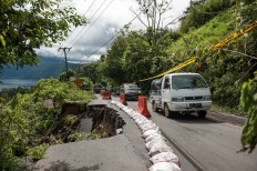 Vehicles pass a road heading to Songan village that was partially affected by a landslide on Monday, February 13, 2017. JP/ Anggara Mahendra