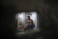 In this Feb. 2, 2017 photo, an inmate sits inside a cell separated from the main prison population, at the Monte Cristo agricultural penitentiary in Boa Vista, Brazil. Many inmates shouted that they need medical attention. AP Photo/Felipe Dana