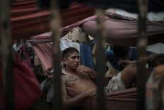 In this Feb. 6, 2017 photo, detainees rest in hammocks inside an overcrowded cell at a police station near Manaus, Brazil. All 24 inmates at the station said they were linked to the Family of the North gang, but guards said that could be just a defensive move after a slaughter at the city's main jail, Complexo Penitenciario Anisio Jobim. AP Photo/Felipe Dana