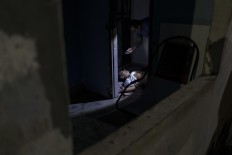 In this Feb. 5, 2017 photo, police inspect a murder victim on the floor of a home in Manaus, Brazil. The increasingly violent city is a thoroughfare for drug trafficking across South America, where authorities suspect most murders are gang related. AP Photo/Felipe Dana