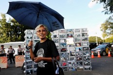 Never forget: Maria Catarina Sumarsih, whose son was killed during the 1998 protests, holds a black umbrella during the commemoration for the 10th anniversary of the Kamisan rally. The Kamisan rally is a silent protest held every Thursday since it was launched by rights activists in 2007.