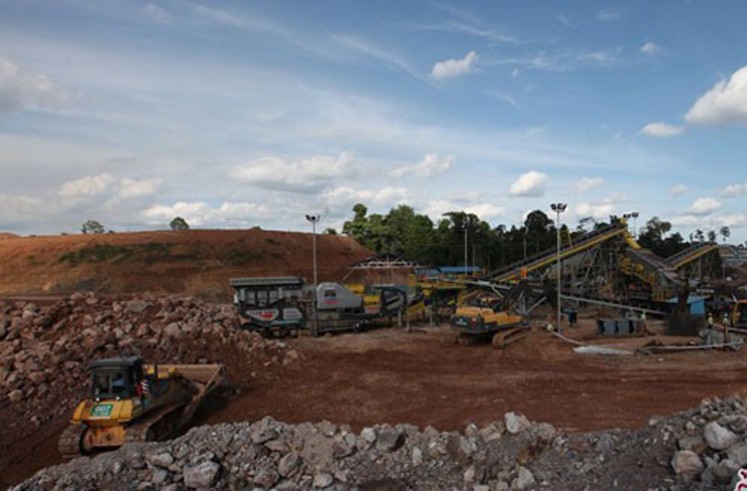 Bright clouds sweep across clear skies on Jan. 28, 2014, above heavy equipment at a gold mine operated by PT Sago Prima Pratama in Nunukan, North Kalimantan. (Antara/Agus W.)
