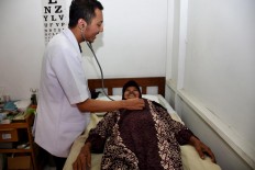 A doctor checks a female patient during the free health program in the Indonesia Medika Clinic Malang, East Java, on Tuesday (21/2). JP/ Aman Rochman