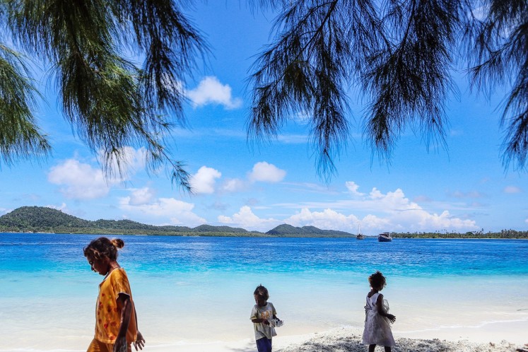 Blue is the warmest color: Children play on a beach on one of the Fam Islands, one of Raja Ampat's conservation zones.