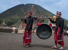 Two men carry a gong for the wedding ceremony at Luhur Poten temple, Mount Bromo. JP/Tarko Sudiarno 