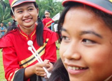 Two female marching band members smile before getting ready for the celebration. JP/Ganug Nugroho Adi

