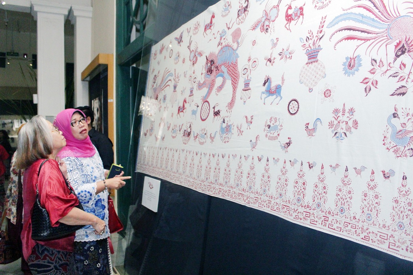 Visitors take a closer look at a piece of batik 'pesisir' with a 'bang biru' (red and blue) motif at the Textile Museum in Tanah Abang, Central Jakarta.