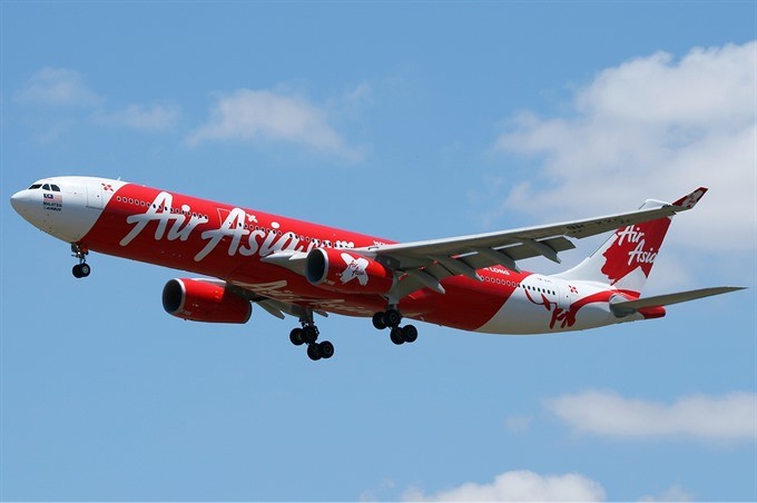 Open air: An AirAsia airplane is seen flying in the air in this undated photograph. AirAsia Berhad, the Malaysian budget airline, plans to begin a low-cost carrier in Vietnam in cooperation with local businesses. 