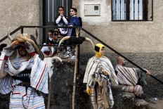 In this April 1, 2017 picture revelers from Navalosa village wearing the traditional 'Cucurrumacho' mask and outfit rest after a parade during a gathering of different villages' carnival masks and characters in the small village of Casavieja, Spain, Monday, April 3, 2017. AP /Daniel Ochoa de Olza
