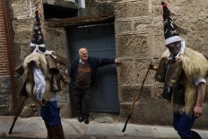 In this April 1, 2017 picture a man representing a wild bear runs through 'Zarramacos' ringing their cowbells in representation of the traditional carnival of La Vijanera de Silio during a gathering of different villages' carnival masks and characters, in Casavieja, Spain, Monday, April 3, 2017. These festivals, held across central and northwestern Spain, most often coincide with festivities celebrating the advent of spring, mixing Carnival and bizarre pagan-like rituals with mock battles between good and evil. AP /Daniel Ochoa de Olza
