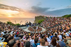 Tourists watch a traditional Balinese 'kecak' dance at Uluwatu Temple in Bali. 