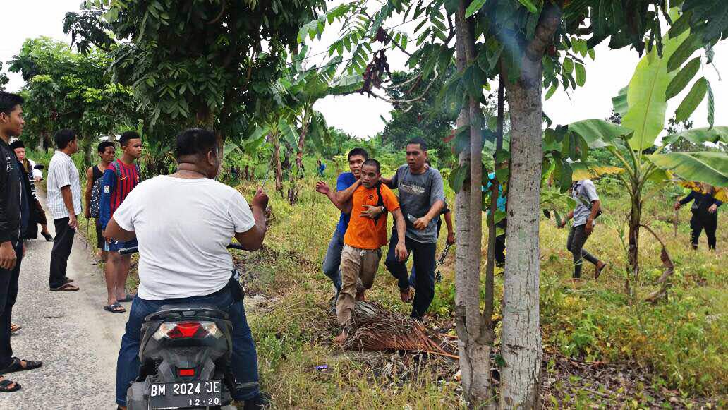 Busted: Police personnel arrest an inmate fleeing from the Class IIB Sialang Bungkuk Penitentary, Pekanbaru, Riau, at noon on Friday