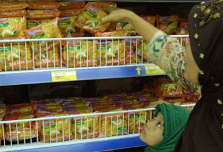 A lady takes packs of instant noodles from a shelf at a convenience store in Jakarta. Indofood Sukses Makmur reported a 7.25 percent increase in sales during the first half of 2019.