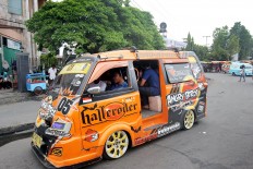 On the roll: Various pictures and slogans adorn a brightly colored angkot public minivan in Padang, West Sumatra.