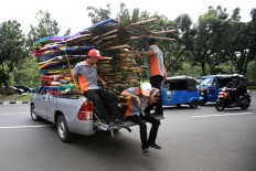 Workers remove dozens of flower boards that were previously on display for several days at the Jakarta governor's office. JP/ Dhoni Setiawan