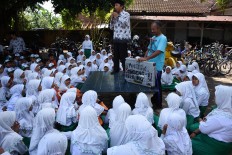 A teacher speaks before Samsudin entertains students on April 4. He told a story about forest conservation and wildlife rescue to the students to give their knowledge on the environment from an early age. JP/Aman Rochman