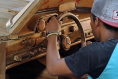 A worker tests the steering wheel of a Mercedes-Benz 300 SL gull-wing replica. JP/Magnus Hendratmo
