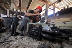 A man pours a resin liquid into a rubber sculpture mold in the Prambanan district, Yogyakarta, on Feb. 21. JP/Aditya Sagita