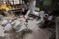 A man uses sandpaper to smooth a cement sculpture after molding it in Patuk village, Gunungkidul, Yogyakarta, on Feb. 21. JP/Aditya Sagita