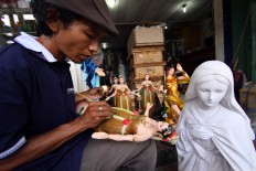 A man uses a fine brush to paint a Mary van Java sculpture at Pajeksan, Yogyakarta, on April 11. JP/Aditya Sagita