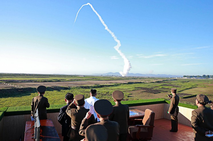 This undated picture released from North Korea's official Korean Central News Agency (KCNA) on May 28, 2017, shows North Korean leader Kim Jong-un (center, in white shirt) watching the test of a new anti-aircraft guided weapon system organized by the Academy of National Defense Science at an undisclosed location. 

