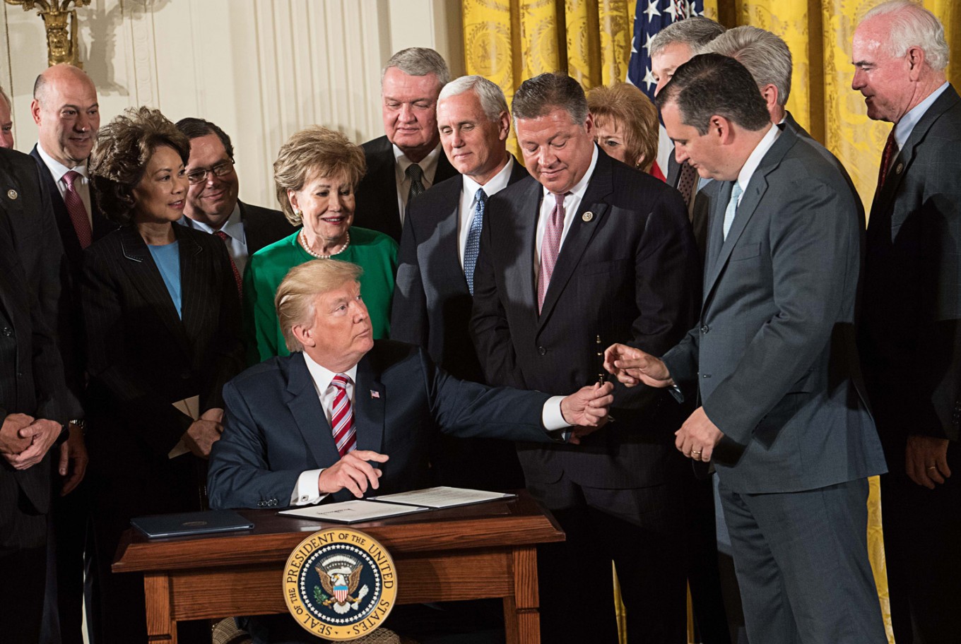 US President Donald Trump hands a pen to Republican US Senator from Texas Ted Cruz after signing a letter of principles on air traffic control reform after announcing the Air Traffic Control Reform Initiative in the East Room at the White House in Washington, DC, on June 5.
