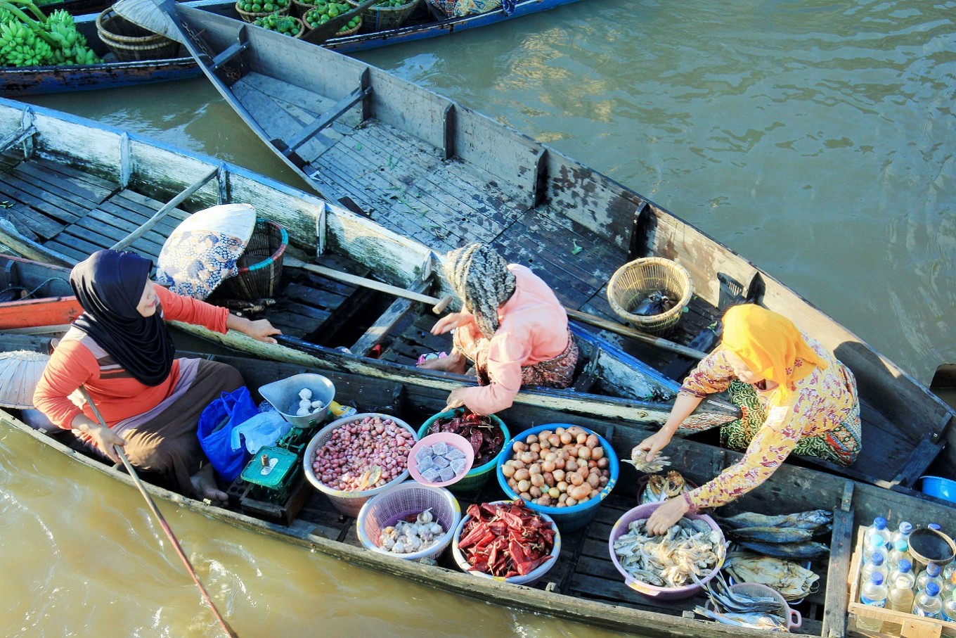 Traditional floating markets are typical of South Kalimantan. They are also known for female sellers aboard rowboats wearing broad-brimmed pandanus hats.