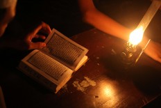 A student recites the Quran outdoors with an oil lamp at Mojosongo, Surakarta, Central Java, on June 11. JP/Maksum Nur Fauzan