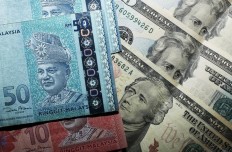 Malaysian ringgit notes are seen among US dollar bills in this photo illustration taken in Singapore in August 2015.