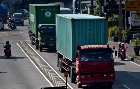 On the move: Two trucks pass through Jl. Diponegoro in Ungaran, Semarang, Central Java, on June 17.