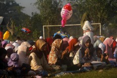 Colorful balloons for sale adorn the background in Payaman, Secang, Magelang, Central
Java, as the Idul Fitri mass prayer is observed in a local field on Sunday, June 25, 2017. JP/Syamsul Huda M. Suhari