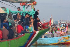 A female tourist sits among locals on board a boat heading for Jepara Bay for the Lomban Festival. JP/Maksum Nur Fauzan