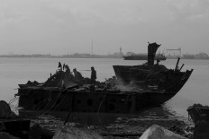 Three workers cut the hull of a ship. JP/Sigit Pamungkas