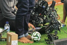 A participant prepares his humanoid soccer robot for the nationwide competition. The robot can chase and kick the ball with the help of a sensor and algorithm chip. JP/Arya Dipa
