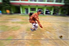 A new student of SMK 1 Pundong state vocational high school in Bantul regency, Yogyakarta, runs during the cengkir (coconut shell) race during the school orientation program on Wednesday, July 19, 2017. JP/Aditya Sagita