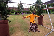 A male student gestures after passing between two trees in the masangin competition in the school orientation program. JP/Aditya Sagita