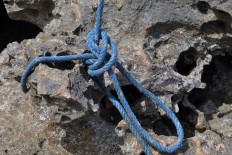 A piece of rope is tied to a rock to support the wooden pole. JP/Magnus Hendratmo