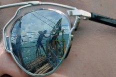 A reflection of a tourist’s sunglasses before crossing to the Timang islet. JP/Magnus Hendratmo