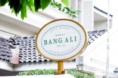 Front gate: The Kedai Bang Ali sign greets customers at the front gate of the family home, where the coffee shop is located in Ali Sadikin's garage.