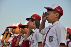 Long hard climb: Students clamber over a wall to reach their school in Kupang 