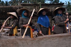 Four women play the gejok lesung, a rice mortar that doubles as a musical instrument during the paddy harvest, accompanied by the karawitan (a Javanese orchestral instrument). JP/ Magnus Hendratmo