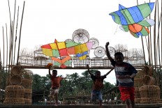Three boys run to fly a kite at Bunder village. The kites are made of bamboo with creative shapes and colors. People of Bunder mostly work as a bamboo weavers producing cages. JP/ Magnus Hendratmo